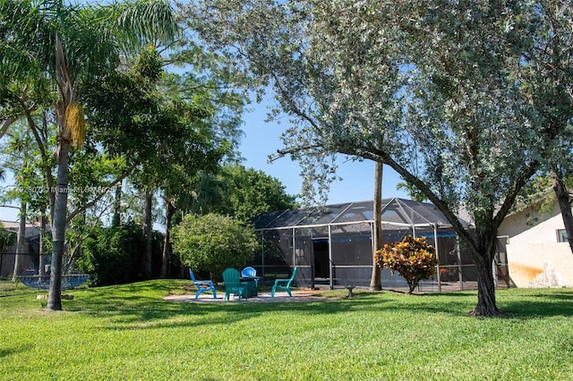 back of property featuring glass enclosure, fence, and a yard