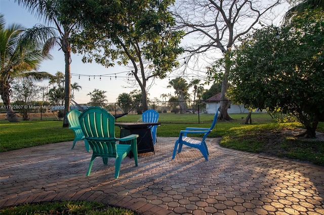view of community featuring fence, a lawn, and a fire pit