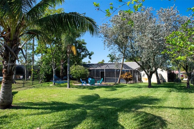 view of yard featuring glass enclosure and fence