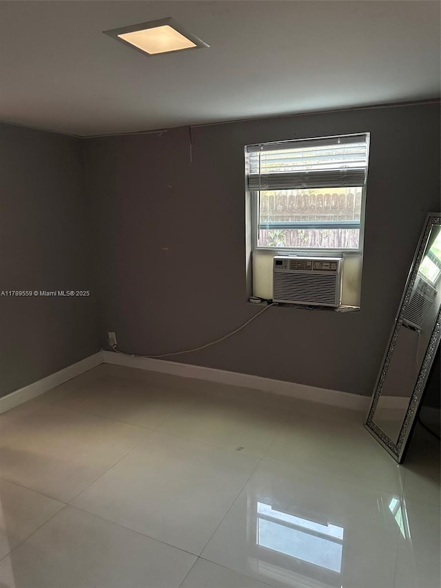 spare room with tile patterned floors, baseboards, and cooling unit
