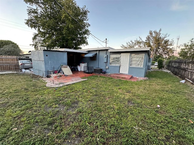 back of house with a yard, fence private yard, and central air condition unit