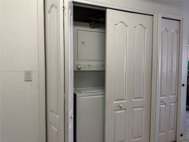 8838 W Flagler St Unit 202, Miami, FL 33174 - laundry room featuring stacked washer / dryer and a textured wall