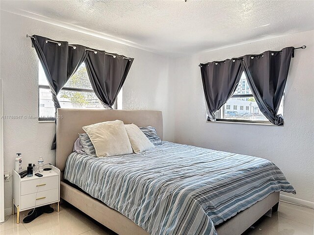 14320 NE 18th Ave, Miami, FL 33181 - tiled bedroom with a textured ceiling, a textured wall, multiple windows, and baseboards