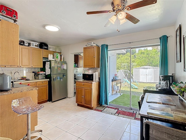 14320 NE 18th Ave, Miami, FL 33181 - kitchen featuring black microwave, light countertops, freestanding refrigerator, a ceiling fan, and light tile patterned floors