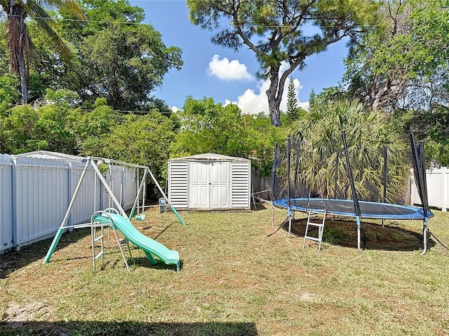 14320 NE 18th Ave, Miami, FL 33181 - view of yard with a fenced backyard, a storage unit, a playground, a trampoline, and an outbuilding