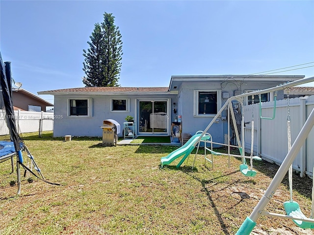 14320 NE 18th Ave, Miami, FL 33181 - rear view of property featuring a fenced backyard, a playground, stucco siding, and a yard