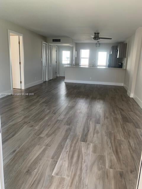 spare room featuring baseboards, a ceiling fan, wood finished floors, and visible vents