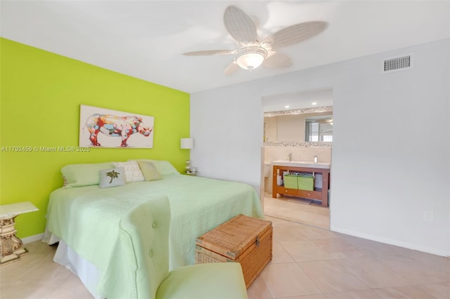 tiled bedroom with baseboards, a ceiling fan, ensuite bath, and visible vents