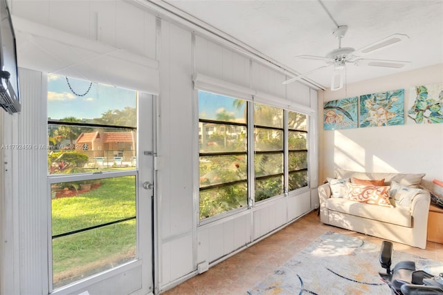 sunroom / solarium featuring a ceiling fan