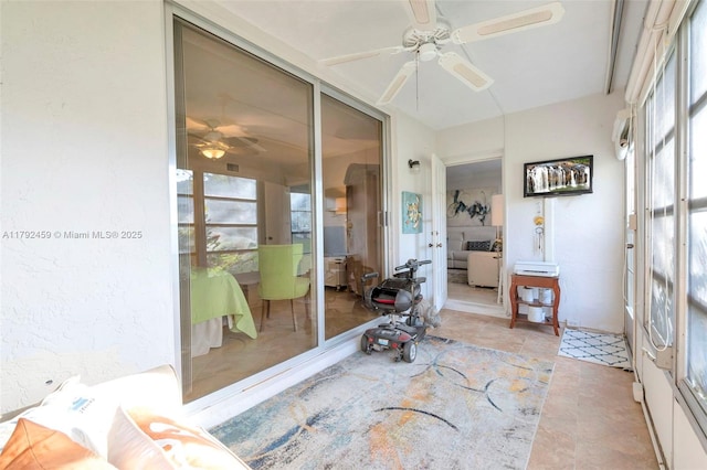sunroom featuring ceiling fan and a healthy amount of sunlight
