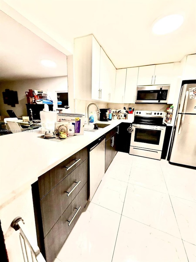 1401 NE 191st St Unit D201, Miami, FL 33179 - kitchen featuring a sink, light countertops, stainless steel appliances, and white cabinetry