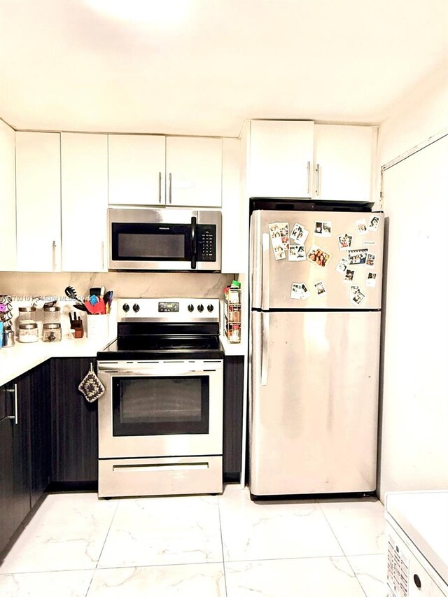 1401 NE 191st St Unit D201, Miami, FL 33179 - kitchen featuring light countertops, marble finish floor, appliances with stainless steel finishes, and white cabinets