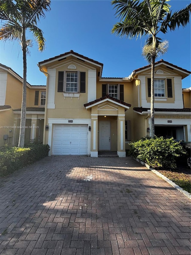 view of front of home featuring a garage, stucco siding, and decorative driveway