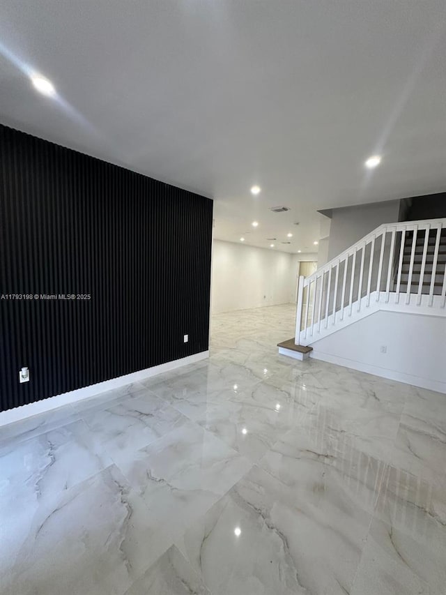 unfurnished living room featuring recessed lighting, stairway, baseboards, and marble finish floor