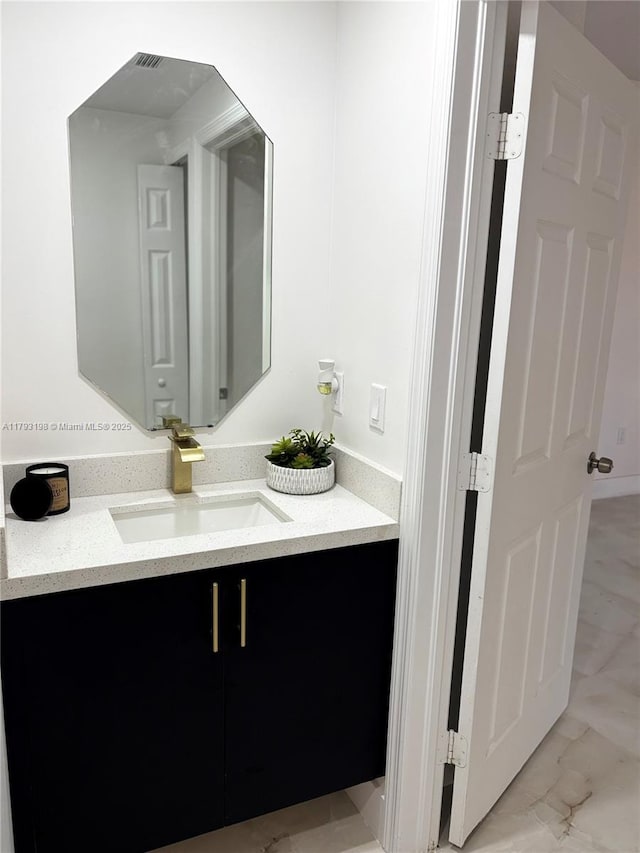 bathroom featuring marble finish floor and vanity