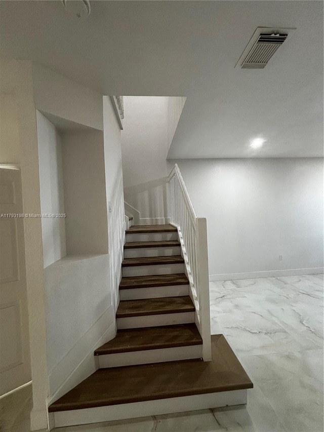 stairway featuring visible vents and marble finish floor