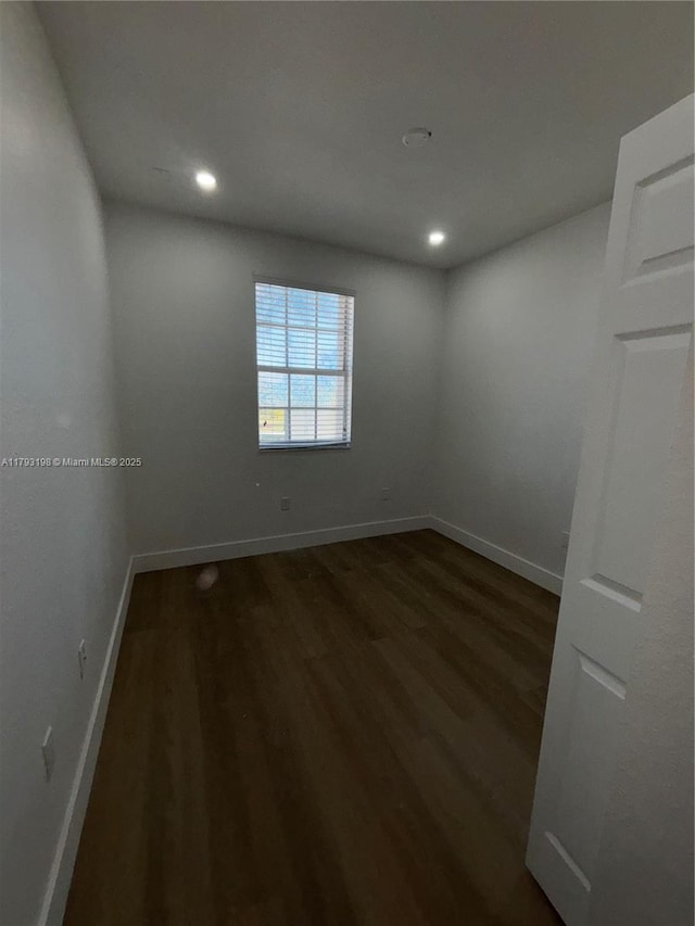 empty room featuring baseboards, recessed lighting, and dark wood finished floors