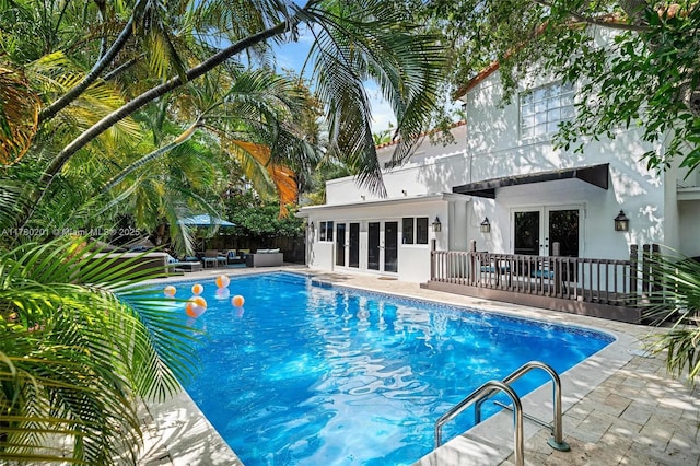 view of swimming pool with a patio, a fenced in pool, french doors, and fence