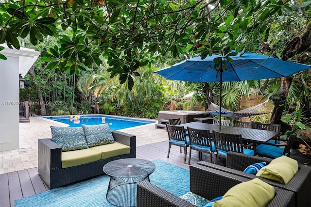 outdoor pool with an outdoor living space, a deck, a patio, a jacuzzi, and outdoor dining space
