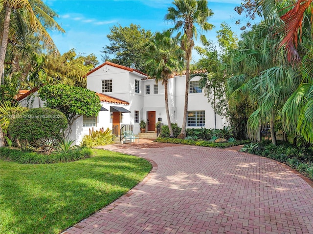 mediterranean / spanish home with stucco siding and a front yard