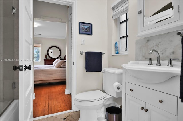 bathroom with vanity, toilet, tasteful backsplash, and ensuite bath
