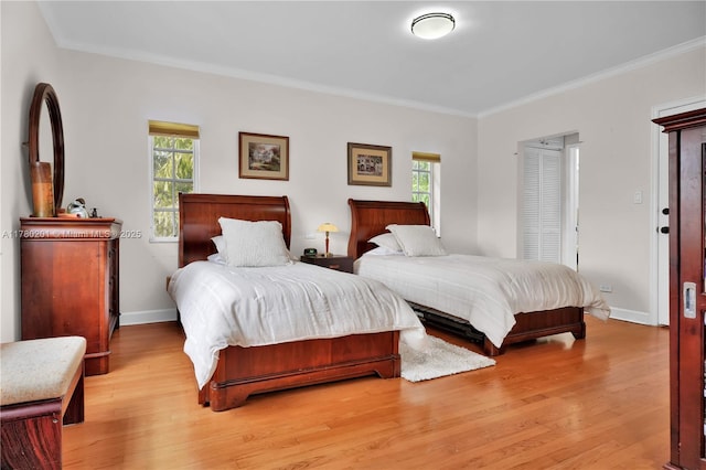 bedroom featuring baseboards, ornamental molding, and light wood-type flooring