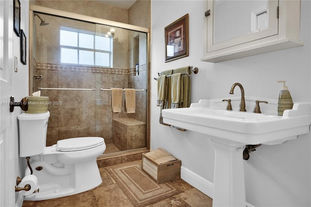 bathroom featuring baseboards, a stall shower, and toilet