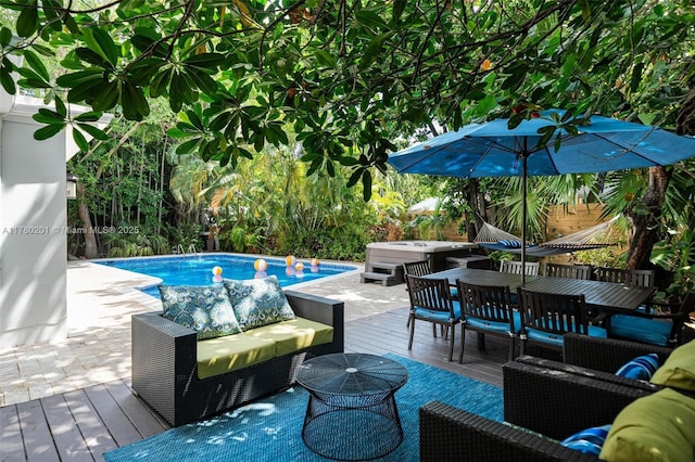 outdoor pool with outdoor dining area, a deck, a patio area, outdoor lounge area, and a jacuzzi