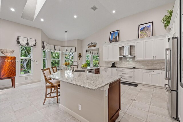 10605 Indian Trl, Cooper City, FL 33328 - kitchen featuring wall chimney range hood, a sink, freestanding refrigerator, vaulted ceiling, and visible vents