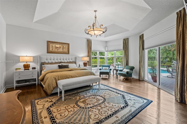10605 Indian Trl, Cooper City, FL 33328 - bedroom featuring a textured ceiling, access to outside, multiple windows, and wood finished floors