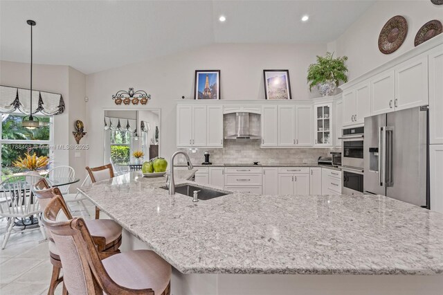10605 Indian Trl, Cooper City, FL 33328 - kitchen featuring white cabinets, appliances with stainless steel finishes, a sink, wall chimney exhaust hood, and lofted ceiling