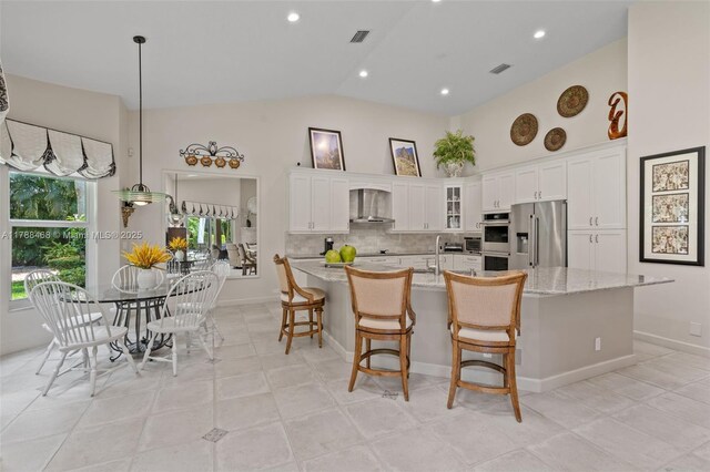 10605 Indian Trl, Cooper City, FL 33328 - kitchen with a large island, wall chimney range hood, white cabinetry, tasteful backsplash, and stainless steel appliances