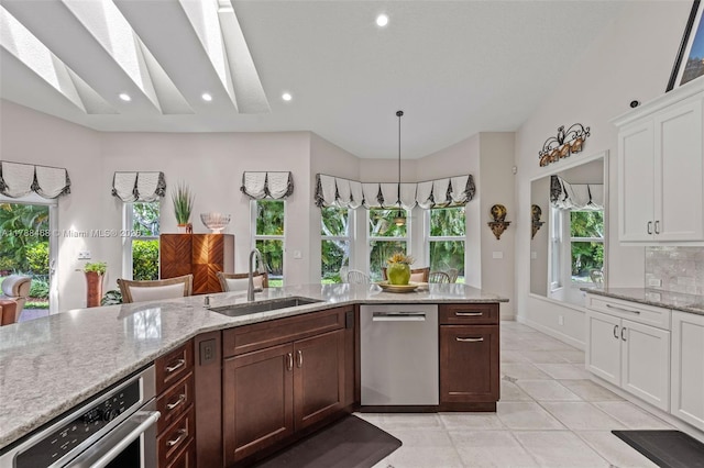 10605 Indian Trl, Cooper City, FL 33328 - kitchen featuring light stone countertops, a sink, light tile patterned flooring, stainless steel appliances, and white cabinetry