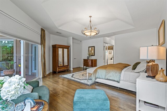10605 Indian Trl, Cooper City, FL 33328 - bedroom featuring access to outside, a tray ceiling, visible vents, and wood finished floors