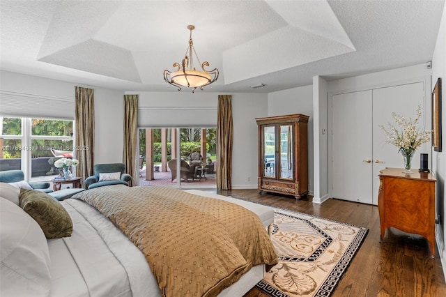10605 Indian Trl, Cooper City, FL 33328 - bedroom featuring baseboards, wood finished floors, a tray ceiling, and multiple windows