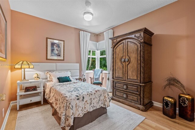10605 Indian Trl, Cooper City, FL 33328 - bedroom with baseboards, a textured ceiling, and light wood-style flooring