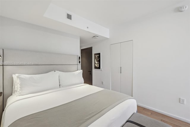 398 NE 5th St Unit 1805, Miami, FL 33132 - bedroom featuring baseboards, a closet, wood finished floors, and visible vents