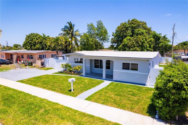 5397 W 14th Ct, Hialeah, FL 33012 - view of front of house with fence, stucco siding, driveway, and a front lawn