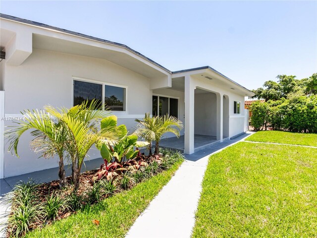 5397 W 14th Ct, Hialeah, FL 33012 - entrance to property featuring a lawn, a patio, and stucco siding