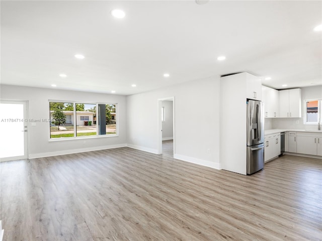 5397 W 14th Ct, Hialeah, FL 33012 - unfurnished living room with recessed lighting, light wood-style flooring, and a wealth of natural light