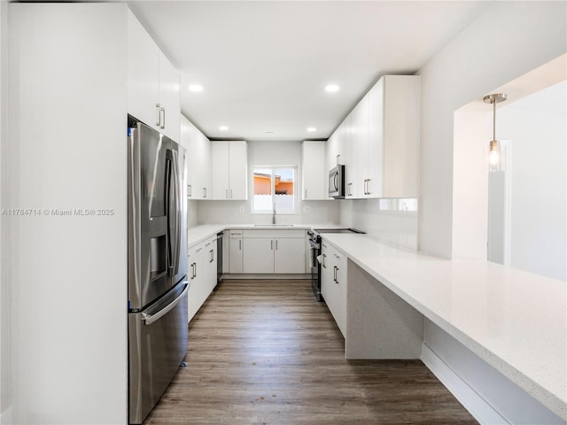 5397 W 14th Ct, Hialeah, FL 33012 - kitchen with light countertops, stainless steel appliances, a sink, and wood finished floors