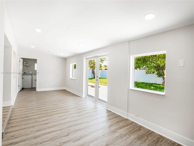 5397 W 14th Ct, Hialeah, FL 33012 - unfurnished living room with baseboards, light wood-style floors, recessed lighting, washing machine and clothes dryer, and french doors