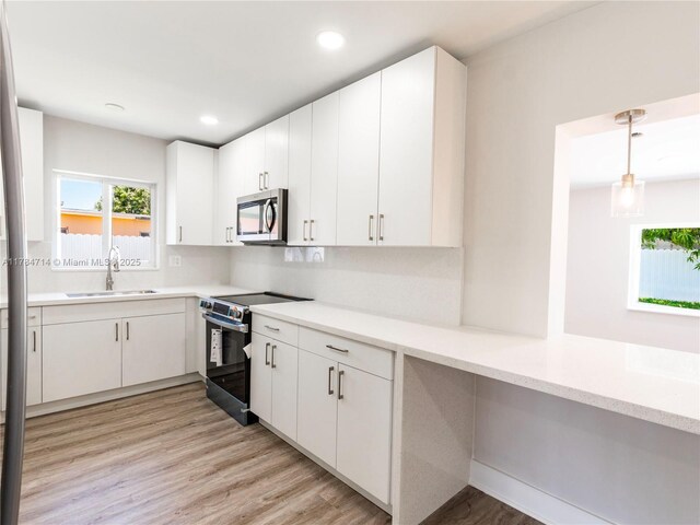 5397 W 14th Ct, Hialeah, FL 33012 - kitchen with light countertops, stainless steel appliances, white cabinetry, and a sink