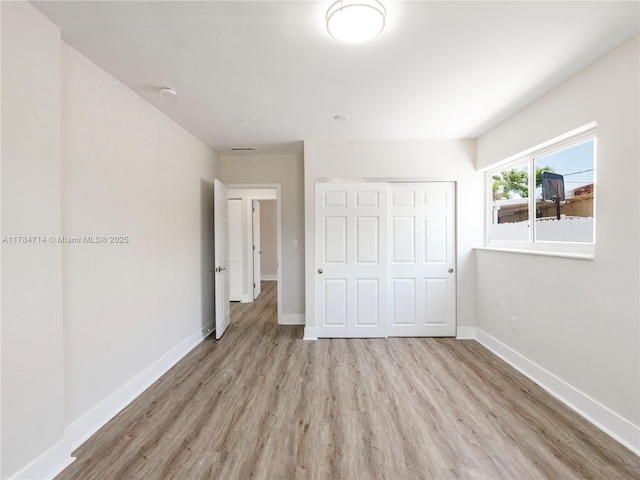 5397 W 14th Ct, Hialeah, FL 33012 - unfurnished bedroom featuring baseboards, a closet, and wood finished floors