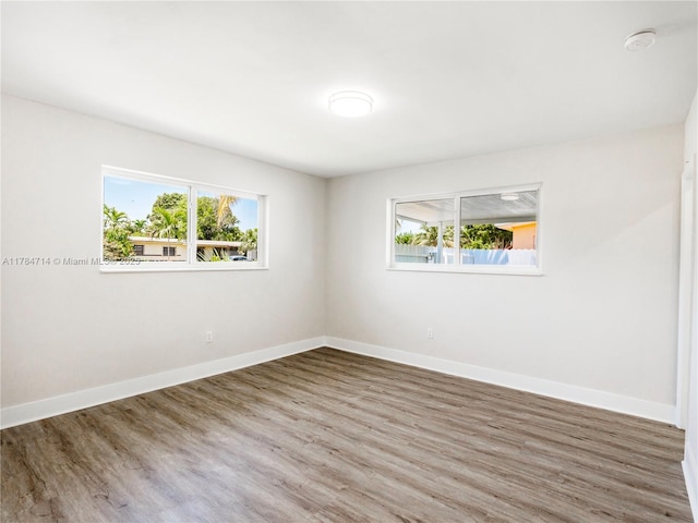 5397 W 14th Ct, Hialeah, FL 33012 - spare room featuring baseboards, wood finished floors, and a wealth of natural light