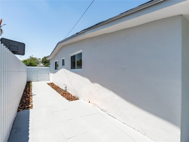 5397 W 14th Ct, Hialeah, FL 33012 - view of side of home featuring fence, a patio area, and stucco siding