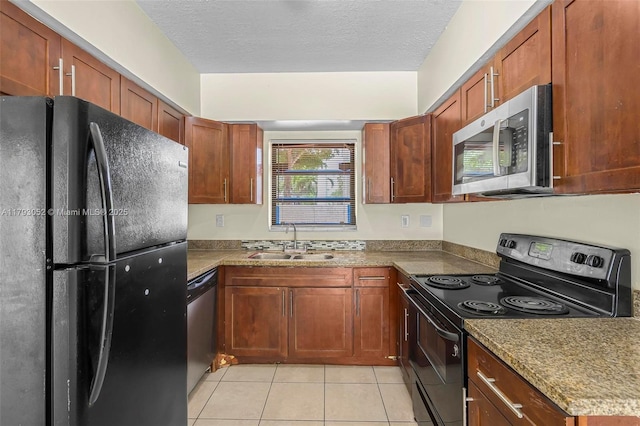 kitchen with a sink, a textured ceiling, light tile patterned floors, and black appliances