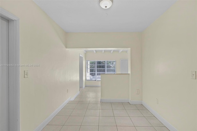 spare room with baseboards and light tile patterned floors