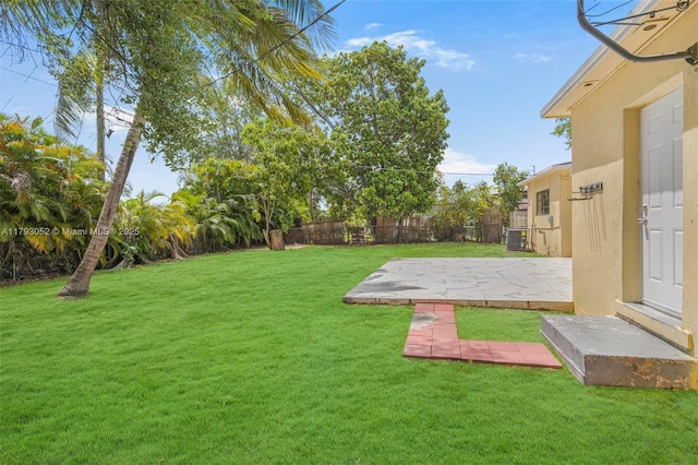 view of yard featuring a fenced backyard, a patio, and central air condition unit