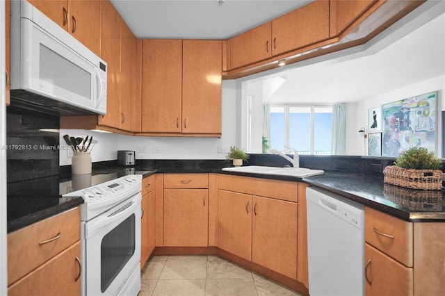 801 Brickell Key Blvd Unit 3105, Miami, FL 33131 - kitchen with a sink, a peninsula, dark stone counters, white appliances, and light tile patterned flooring